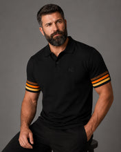 Man wearing a black polo shirt with striped sleeves against a gray background
