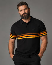 Man wearing a black polo shirt with orange and brown stripes on a gray background