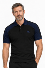 A man wearing a black and navy blue short-sleeve polo shirt with a small blue 'NC' logo on the left chest, photographed against a clean white background.