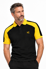 A man wearing a black and yellow short-sleeve polo shirt with a yellow collar and a yellow embroidered 'NC' logo on the chest, posed against a solid white background.